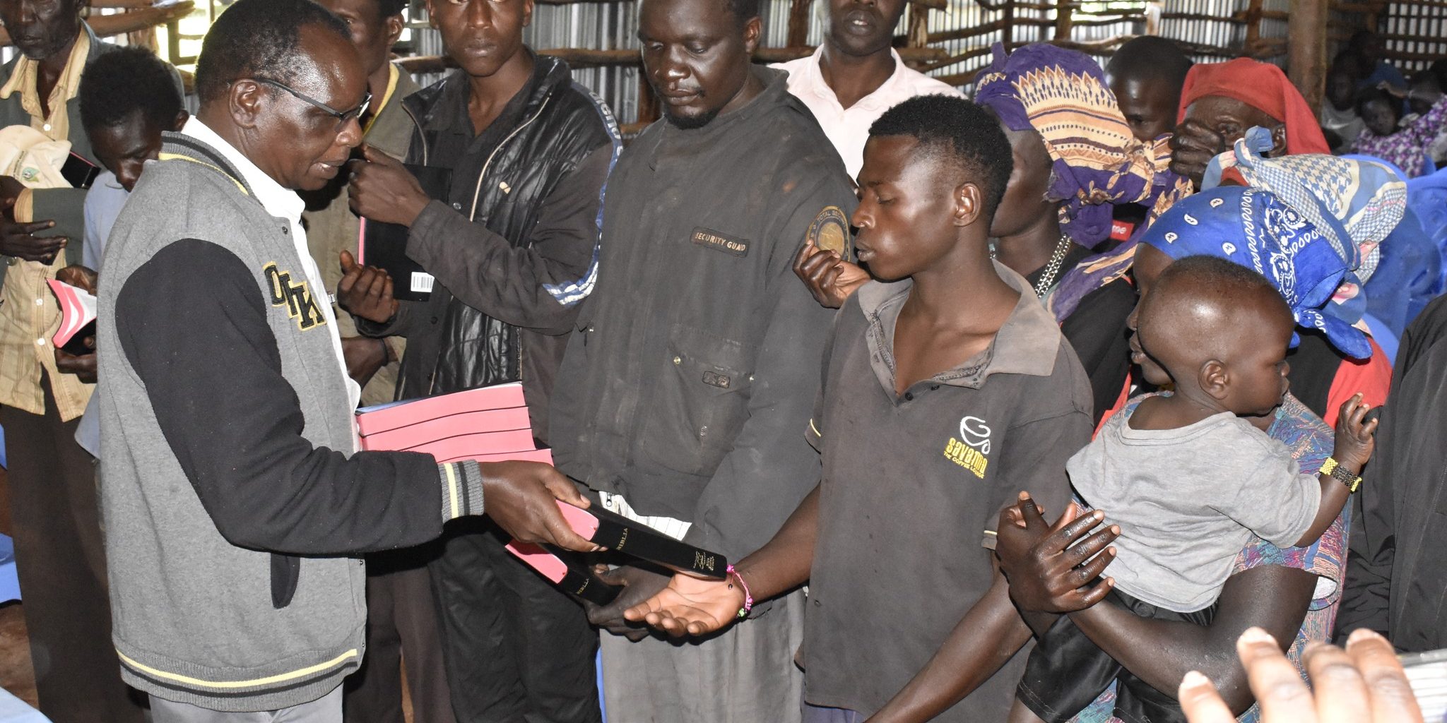 Rev Ptallah Butaki giving Bibles to the saved souls at Section six Kitale on 7th Dec 2024